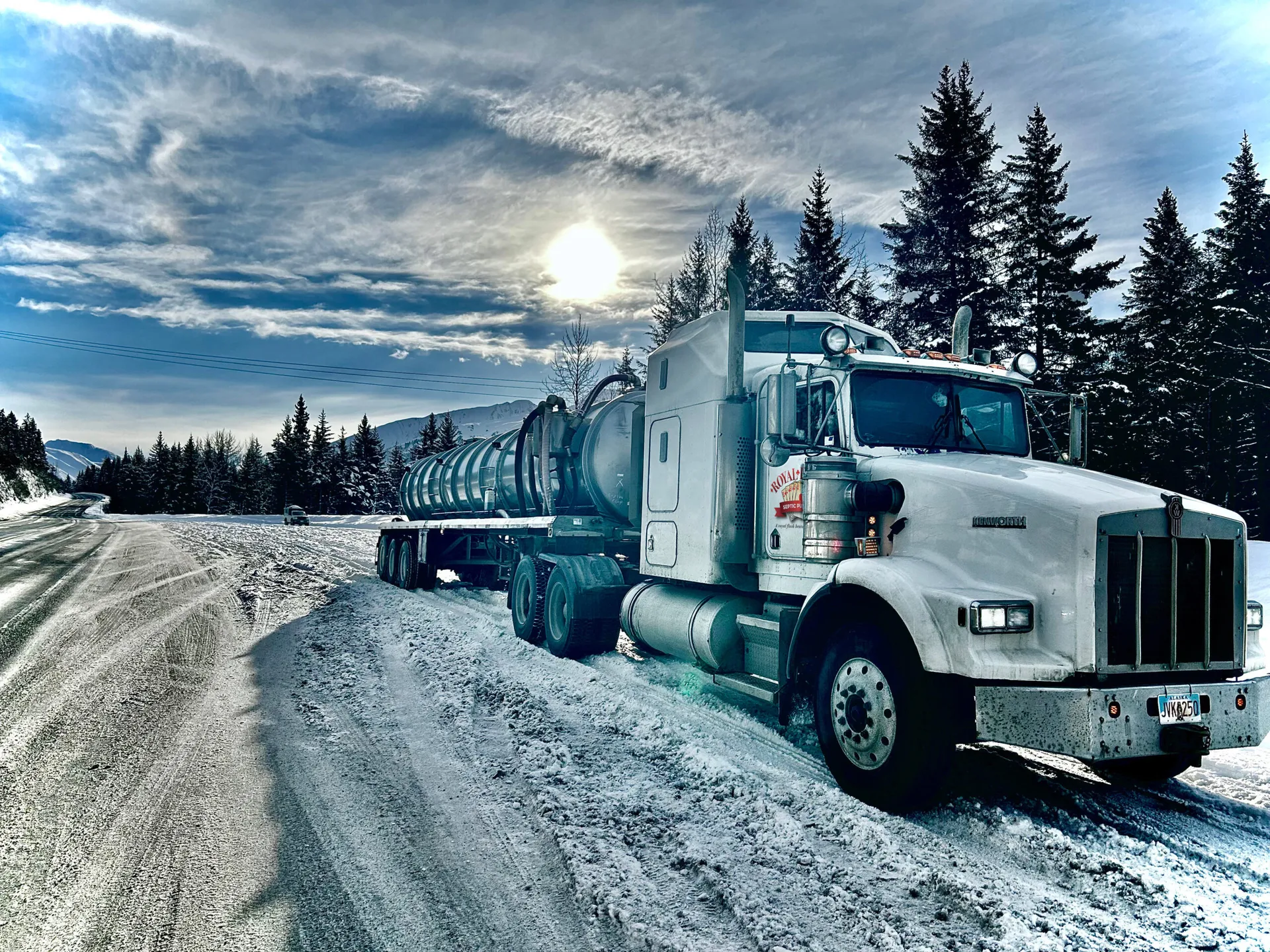 A beautiful Royal Flush septic tanker truck parked on a snowy road, showcasing the Royal Flush logo prominently on the side.